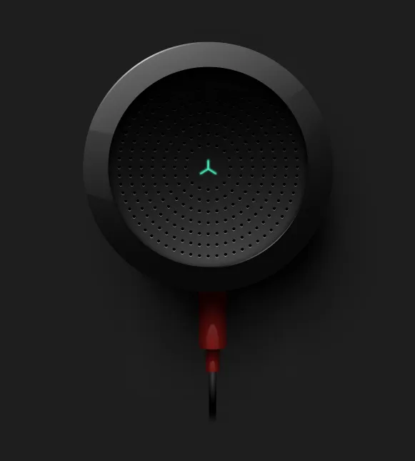 A round black speaker with a perforated grille and a red cable, lit from above